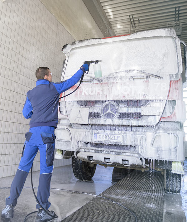 Technician using Kranzle pressure washer to clean a large truck